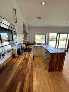 a kitchen with wooden floors and a large counter top at London City Ensuite Room City Airport&London Excel Exhibition Center in London