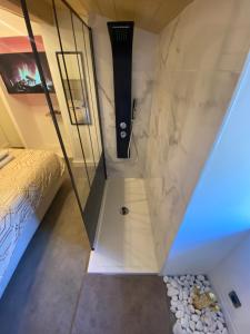 Le Foyer d'Or - Hypercentre & Confort في آجا: غرفة بسرير وجدار زجاجي