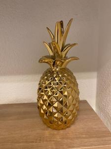 eine goldene Ananas auf einem Holztisch in der Unterkunft Le Foyer d'Or - Hypercentre & Confort in Agen