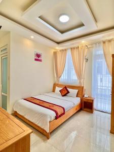 een slaapkamer met een bed in een kamer bij Khách sạn Hải Hoa Đà Lạt in Da Lat