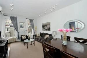 een woonkamer met een tafel en een bank bij Cozy 1BR Apartment in Upper West Side! in New York