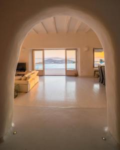 ミコノス・シティにあるAlia Luxury Villa Mykonosの海の見えるリビングルームのアーチ道