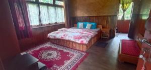 een slaapkamer met een bed en een rood tapijt bij Daragaon Retreat (Gurung Homestay) in Pelling