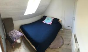 a small bed in a small room with a window at Appart dans longère Normande au coeur de la Forêt de Lyons 