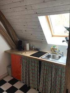 eine Küche mit einem Waschbecken und einem Fenster in der Unterkunft Appart dans longère Normande au coeur de la Forêt de Lyons 