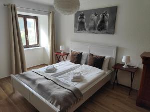 een slaapkamer met een groot wit bed in een kamer bij la ferme de la gaby in Le Noirmont