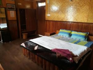 una camera da letto con un grande letto con cuscini blu di Daragaon Retreat (Gurung Homestay) a Pelling