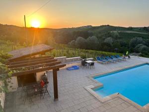 un patio con piscina y puesta de sol en Casa Carolina - Villa/Pool with Bar, 5 bedrooms, 3 bathrooms, Great For Groups., en Castel Rocchero