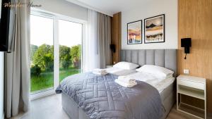 a bedroom with a large bed and a large window at Wonder Home - Domki Hillside tuż przy stoku narciarskim - na terenie kompleksu plac zabaw i zewnętrzna siłownia in Karpacz