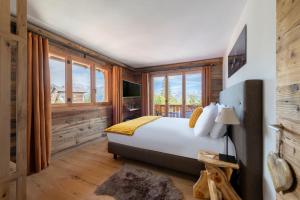 a bedroom with a bed and a large window at PAPILL'ON - Boutique Hotel in La Tzoumaz