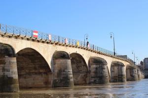 Eine Brücke über einen Fluss mit Leuten, die darauf laufen. in der Unterkunft ''Le Graff'' de Miss.K Conciergerie in Mâcon