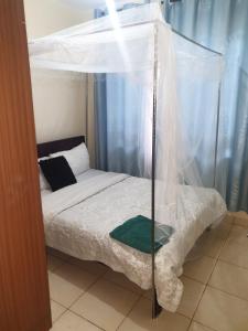 a bedroom with a bed with a canopy at Spacious 3bedroom in Greatwall Gardens in Athi River