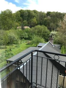 einen Balkon eines Hauses mit Dach in der Unterkunft Appart dans longère Normande au coeur de la Forêt de Lyons 