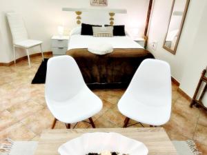 2 sillas blancas y 1 cama en una habitación en Holibai, Ruliña ,Centrica Private Ensuite, Baiona, en Baiona