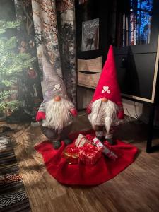 due gnomi statunitensi seduti sul pavimento con regali di Cozy house close to SantaVillage a Rovaniemi