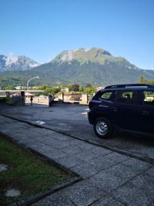 um carro estacionado num parque de estacionamento com montanhas ao fundo em Appartamento Al Parco em Belluno