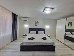 Central Luxe Apartment - Elisha في مدينة فارنا: غرفة نوم بسرير كبير ومرآة كبيرة