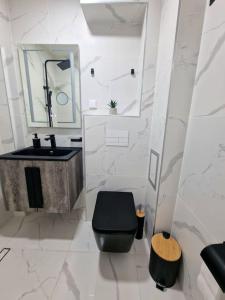 een badkamer met een zwart toilet en een wastafel bij Central Luxe Apartment - Elisha in Varna