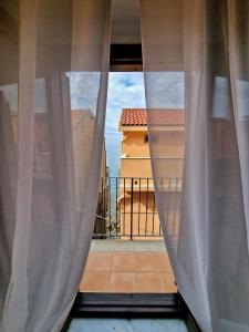 uma janela com vista para uma varanda em LA CASETTA AZZURRA CHIANALEA - locazione turistica em Scilla