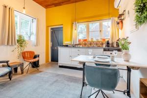 uma cozinha com paredes amarelas e uma mesa e cadeiras em The Corner House em Kampen