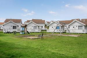 un grupo de casas con un parque con parque infantil en Tanumstrand SPA & Resort Stugor, en Grebbestad