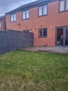 a brick house with a fence and a yard at Stunning 3 bed home at the heart of Wolverhampton in Wolverhampton