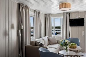 un soggiorno con divano e tavolo di Tanumstrand SPA & Resort Stugor a Grebbestad