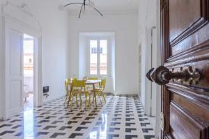 Habitación con mesa y sillas en un suelo a cuadros en Villa Borghese Large Apartment, en Roma