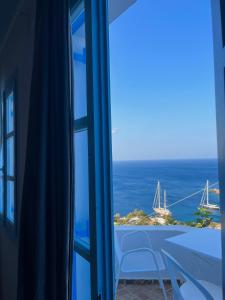 a view of the ocean from a room with a window at Hotel Petradi in Ios Chora
