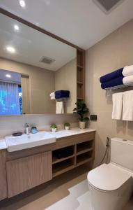 La salle de bains est pourvue d'un lavabo, de toilettes et d'un miroir. dans l'établissement 2 br Laguna, SkyPark, Bang Tao, à Thalang