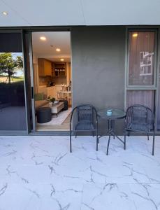 a patio with two chairs and a table and a kitchen at 2 br Laguna, SkyPark, Bang Tao in Thalang