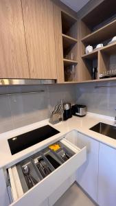 a kitchen with white counters and wooden cabinets at 2 br Laguna, SkyPark, Bang Tao in Thalang