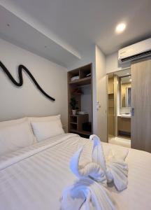 a bedroom with a white bed with a towel on it at 2 br Laguna, SkyPark, Bang Tao in Thalang