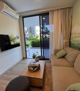 2 br Laguna, SkyPark, Bang Tao في تالانغ: غرفة معيشة مع أريكة وطاولة