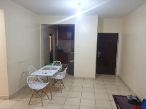 a room with a table and chairs and a kitchen at Spacious 3bedroom in Greatwall Gardens in Athi River