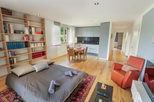 1 dormitorio con 1 cama grande y comedor en Appartement élégant avec terrasse privée, en Villars-sur-Glâne