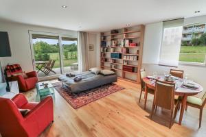 1 dormitorio con 1 cama, mesa y sillas en Appartement élégant avec terrasse privée, en Villars-sur-Glâne