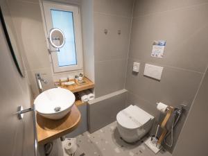 a bathroom with a white toilet and a sink at Monte 21 - San Giusto in Trieste +15 photos