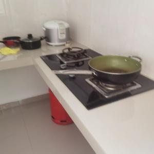 a green bowl on top of a stove in a kitchen at 3a房有厕所厨房冰箱洗衣机 in Kuala Lumpur