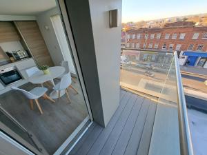 a balcony with a table and chairs and a window at Luxury New 2 Bed/2 Bathroom Flat With Balcony in Edgware