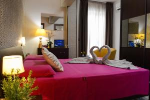 1 dormitorio con 2 cisnes en una cama rosa en B&B Sole Luna, en Marina di Gioiosa Ionica