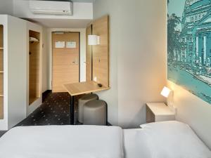 バート・ホンブルク・フォア・デア・ヘーエにあるB&B ホテル バート ホンブルクのベッド2台とデスクが備わるホテルルームです。
