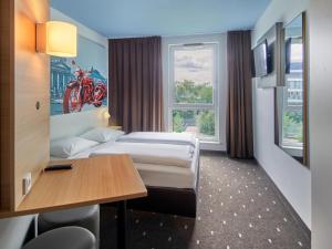 バート・ホンブルク・フォア・デア・ヘーエにあるB&B ホテル バート ホンブルクのベッド2台とテーブルが備わるホテルルームです。