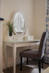 een kaptafel met een spiegel en een stoel bij Rose & Crown Rooms in Beverley