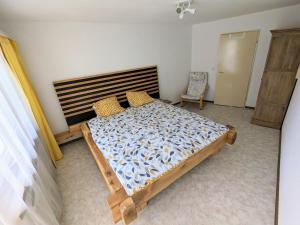 a bedroom with a bed and a chair at Grosses Familiennest cosy komplett renoviert in Leukerbad