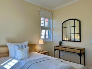 a bedroom with a bed and a mirror and a table at Wohlfühl-Apartment in historischer Burg nahe Fulda in Schlitz