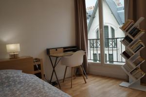 a bedroom with a bed and a desk and a window at Trouville Superbe appartement hyper centre in Trouville-sur-Mer +4 photos
