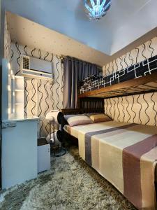 ein Hotelzimmer mit 2 Betten und einem TV in der Unterkunft Elegant Studio at Grass Residences 1-5 persons only, Quezon City in Manila