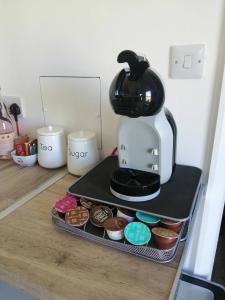 a coffee maker sitting on top of a tray with cupcakes at The Cabin in Pakenham