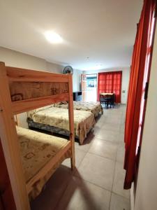 a bedroom with two bunk beds and a table at Santa Teresita Apartments by San Remo in Santa Teresita